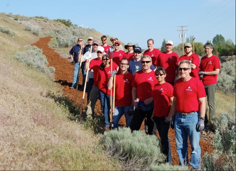 The volunteers from AREVA Inc., Energy Northwest and Tapteal Greenway stand on their newly laid bark hiking trail.